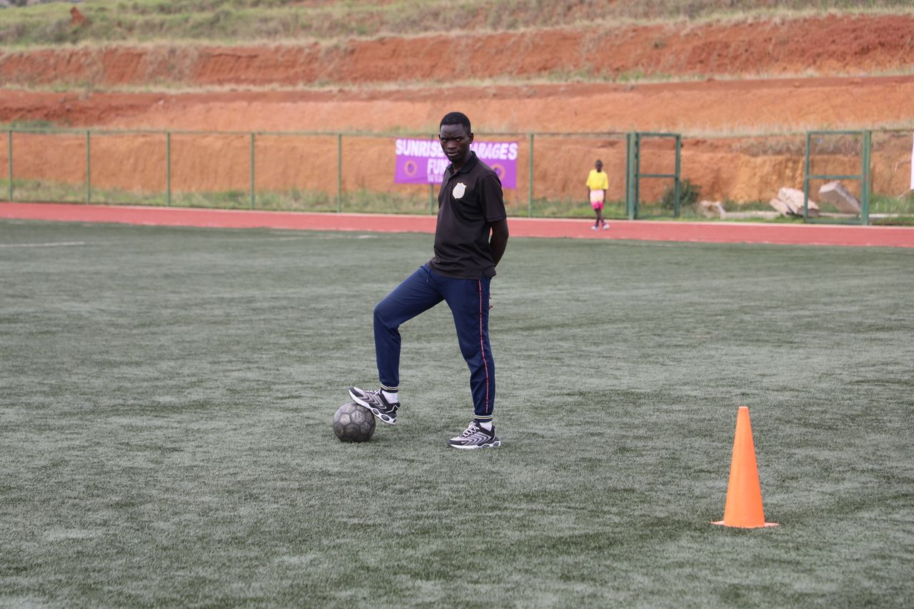 Soccer coach on field preparing for training with a focus on skill development.